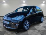 une citrole noire garée sur un sol en damier dans un garage