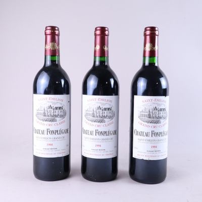 trois bouteilles de vin rouge posées côte à côte sur une table