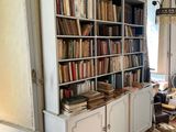 a book shelf with many books on it in the corner of a room
