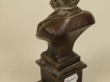 an antique bronze bust of a woman on a pedestal