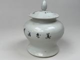 a white vase with a black design on it
