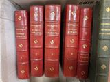 several red books are lined up on a shelf in a book case
