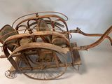 an old fashioned wooden carriage that is sitting on a white surface