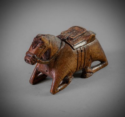 an old wooden figurine of a dog with a saddle