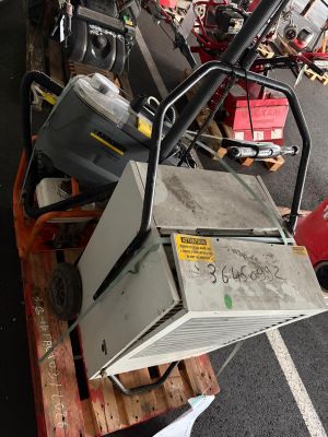 a pile of old appliances on a pallet in a parking lot
