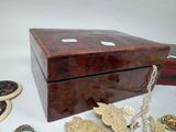 a wooden box that has a bunch of jewelry inside of it