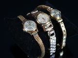deux montres en or et en argent exposées sur un fond noir