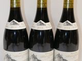 trois bouteilles de vin posées sur une table l'une à côté de l'autre