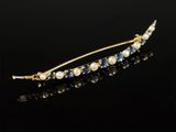 un gros plan d'une épingle à cheveux en or ornée de perles et de saphirs