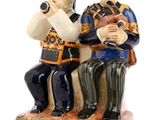 deux figurines d'un homme et d'une femme assis sur un banc