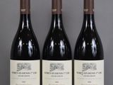 three bottles of wine are lined up on a table