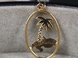 un pendentif plaqué or orné d'un palmier