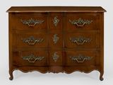 une commode ancienne dotée de poignées ouvragées et d'un plateau en bois