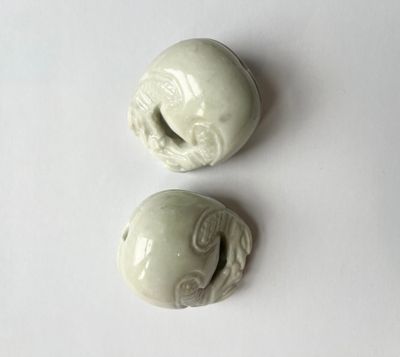 DEUX PETITS GRELOTS en pierre dure sculpté, à décor de deux …