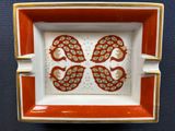 a red and white plate with two birds on it