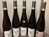 six bouteilles de vin sont alignées sur un tonneau en bois