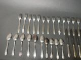 a lot of silver spoons and forks on a table