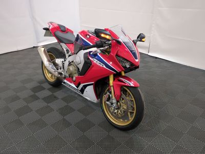 une moto rouge et blanche garée dans un garage