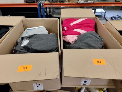 deux cartons contenant des vêtements dans un magasin