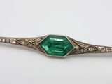 a close up of an emerald and diamond broocher