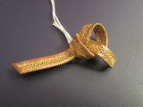 a gold tie with a knot on it on a black surface