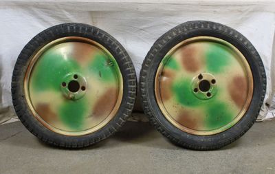 une paire de roues vertes et jaunes avec des jantes noires posées sur un sol en béton