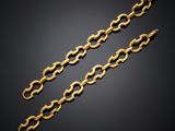 a pair of gold chain bracelets on a black background