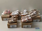 Plusieurs paires de chaussures pour bébé sont exposées dans une boîte
