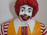 statue of ronald the clown in a red wig and yellow vest