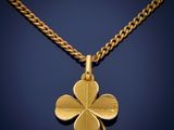 a gold four leaf clover pendant on a gold chain