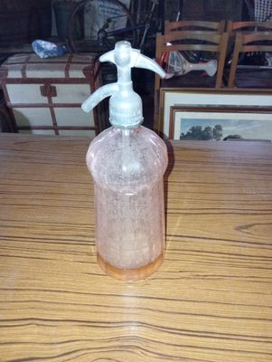 une bouteille en plastique munie d'une pompe, posée sur une table en bois