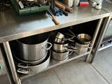 a kitchen with many pots and pans on the counter