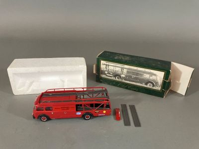 un bus rouge à deux étages à côté d'une boîte de mouchoirs