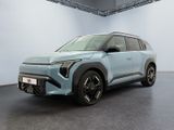 a blue car is parked in a large room with a white wall