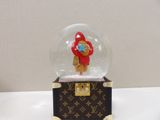 a snow globe with a red teddy bear inside of it