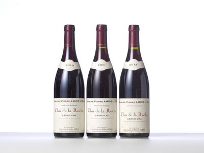 three bottles of wine are lined up on a table