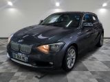 une photo d'une voiture bmw noire garée dans un garage