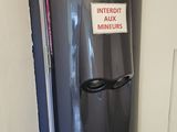 a water heater in the corner of a room with a sign on it