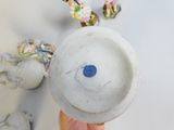 a person holding a white vase with a blue button on it