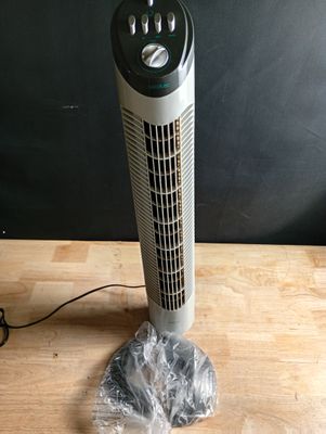 un ventilateur posé sur une table en bois recouverte d'un film plastique
