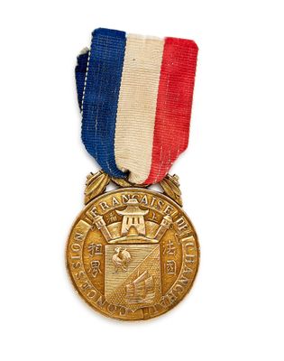 une image représentant une médaille d'or ornée d'un ruban rouge, blanc et bleu