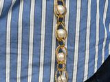 a woman that is wearing a necklace with pearls on it
