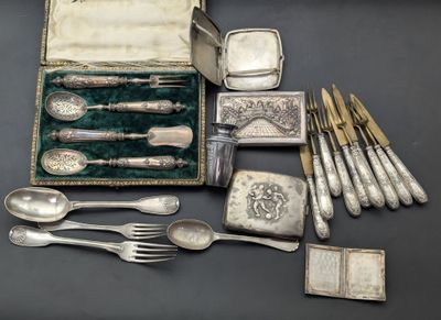 une boîte contenant de l'argenterie et des cuillères en argent posée sur une table