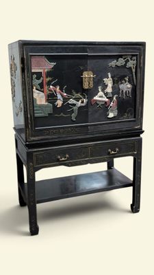 a black cabinet with a painting on it and a shelf