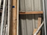 a pile of metal pipes in a room with a red bucket