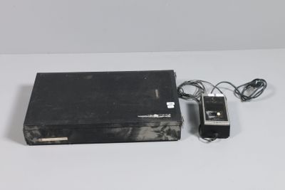 a video game console and a charger on a white surface