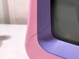 a small pink and purple television sitting on a table