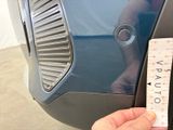 a hand that is holding a ruler next to a car