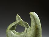 an image of a green sculpture of a fish on a gray surface