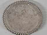 a silver plate with a design on it on a table
